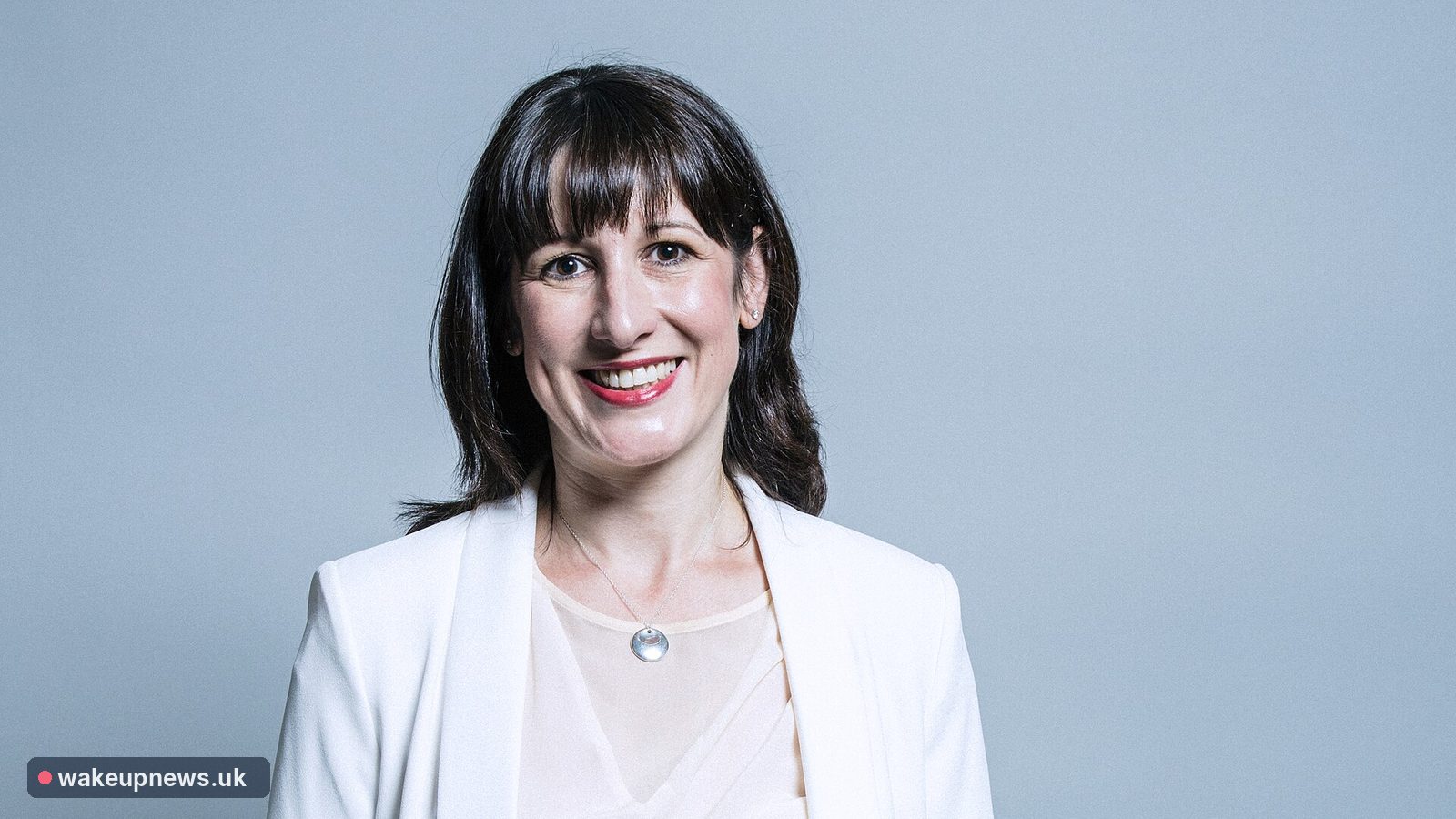 Rachel Reeves smiling in a white jacket against a pale blue background