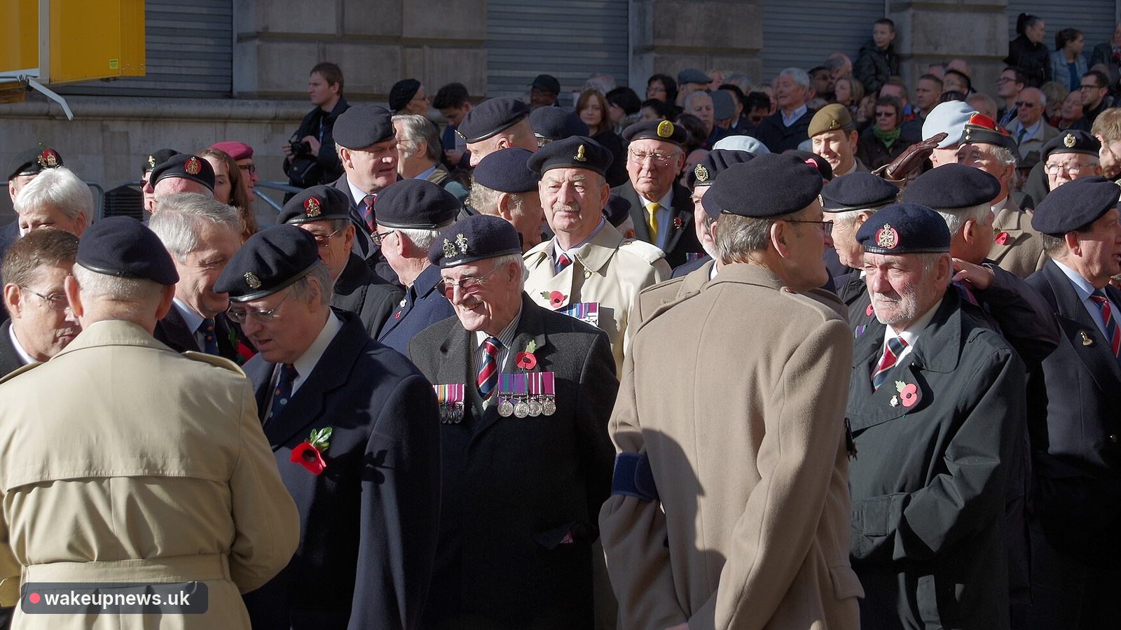 Elderly British veterans in berets and medals gather on Whitehall for Remembrance Sunday