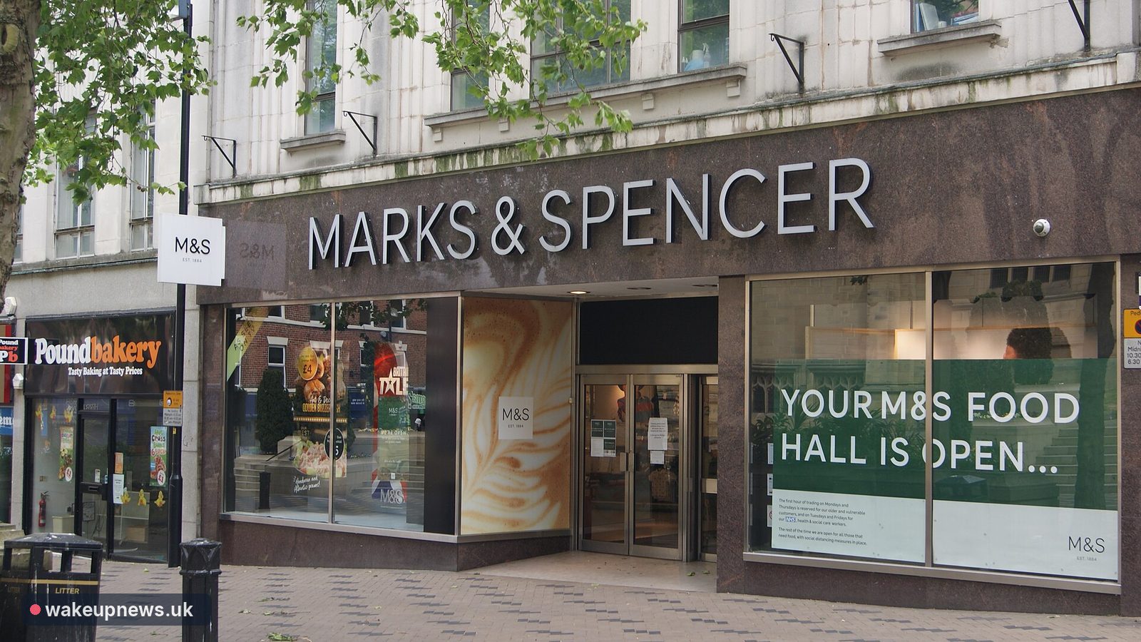 Marks & Spencer store front on a high street with a sign saying the food hall is open