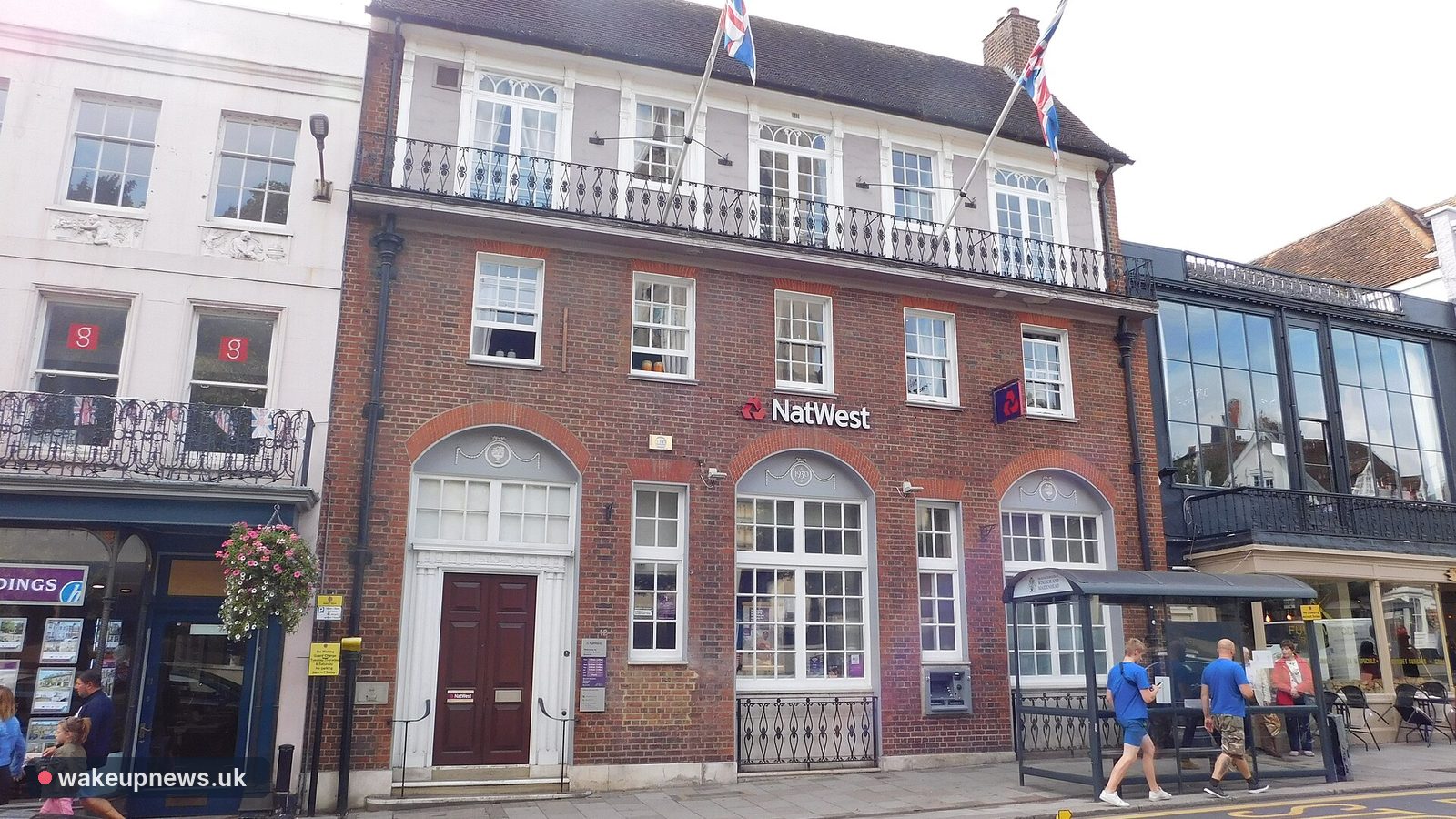 Red-brick NatWest bank branch on Windsor High Street with Union flags flying above