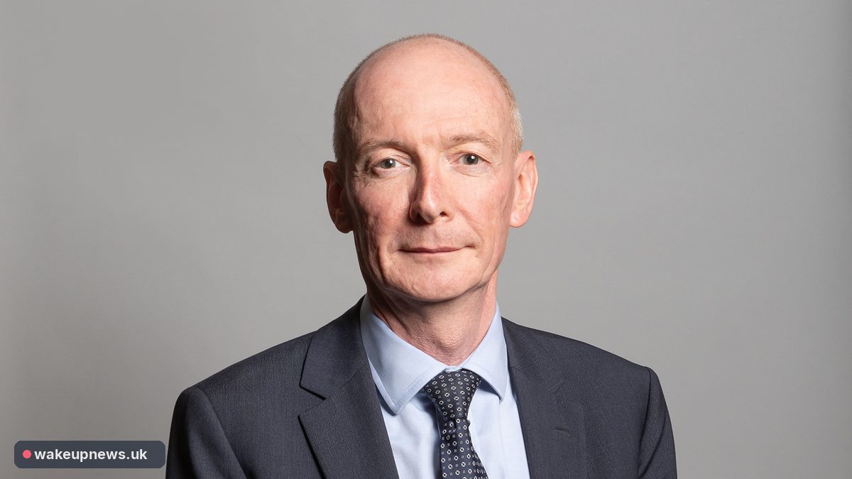 Pat McFadden MP in a dark suit and tie against a grey background