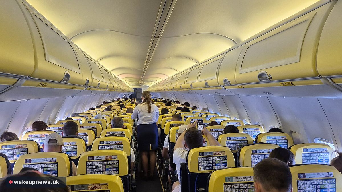 Inside a Ryanair Boeing 737 cabin, with passengers seated in rows of yellow-backed seats